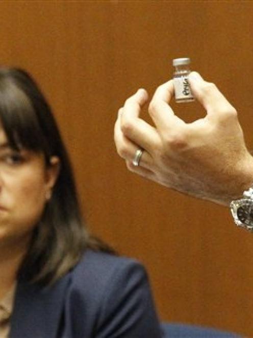 Deputy District Attorney David Walgren holds a bottle found by Los Angeles County coroner...