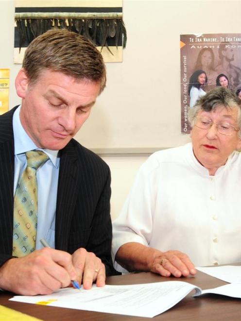 Deputy Prime Minister Bill English and Dame Pat Harrison sign a contract at the Wellness Centre...