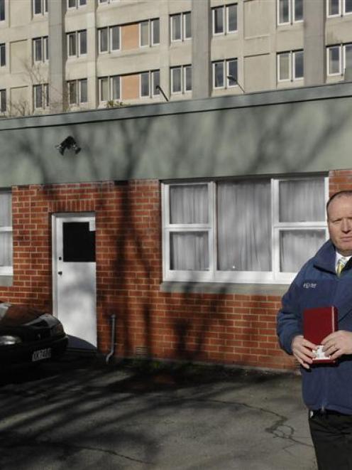 Detective Iain Ferguson inspects an alley off Frederick St, in Dunedin, yesterday. The alley,...