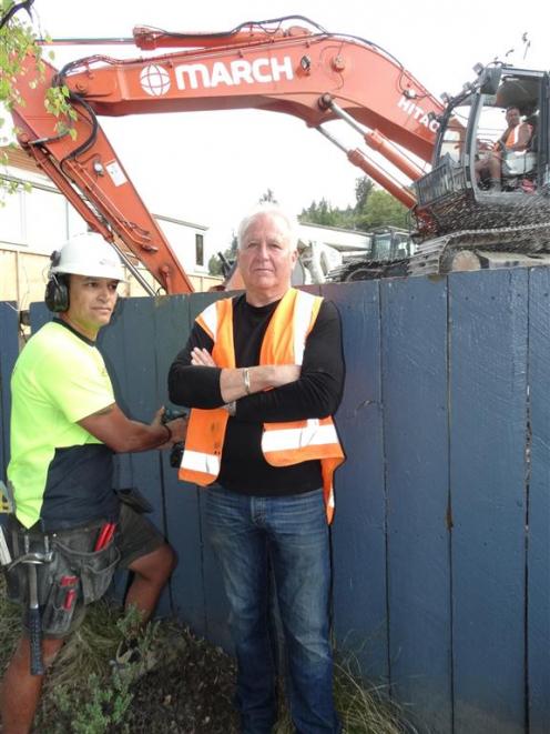 Developer Lew Gdanitz (right) and  building contractor Harry Fleming  beside a fence dividing Mr...