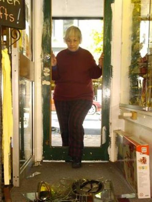 Diana Struthers examines the remains of a stained-glass door she believes was smashed by vandals...