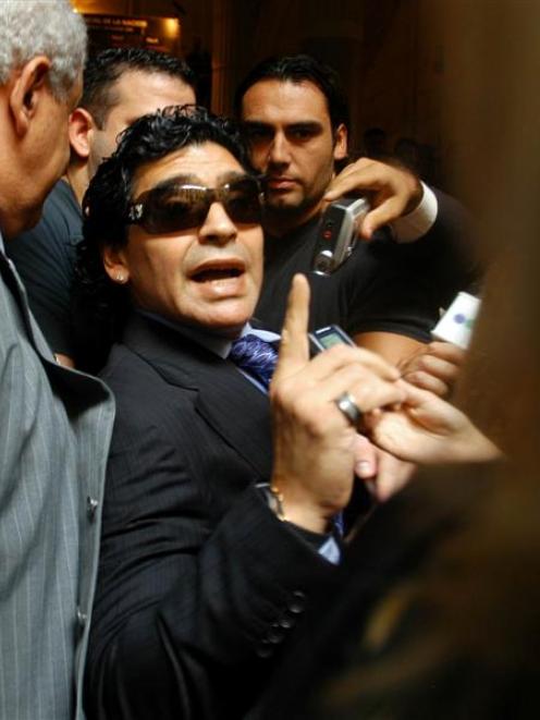 Diego Maradona argues with television reporters as he leaves a courthouse in Buenos Aires....