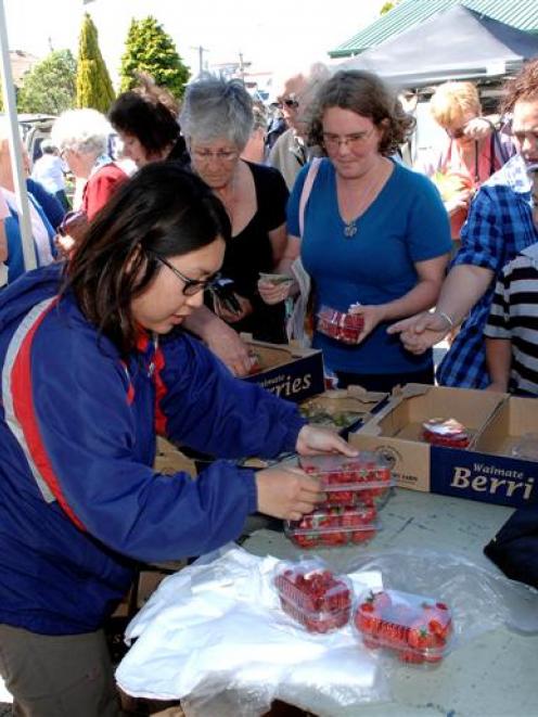 Dishing out fresh berries is Joey Ng of Butlers Berry Farm, at the South Dunedin Otago Farmers...