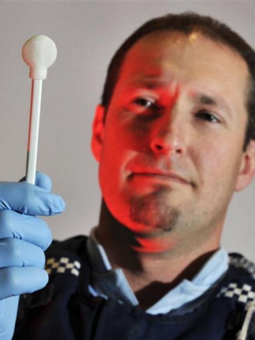 DNAActing Sergeant John Gilbert, of Dunedin, with a swab for collecting DNA samples. Photo by...