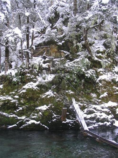 Doc is organising a replacement of the swingbridge across the Routeburn after a snow-laden tree...