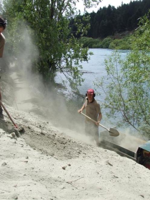 Doc workers Ed Astin and Gavin Mason clear a slip of fine silt from the Outlet Track during a...