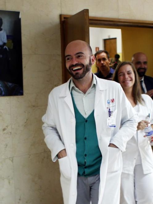 Doctors Fernando de la Calle (centre) and Marta Arsuaga (behind him) leave after a news...