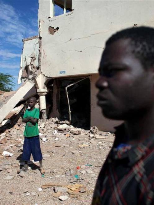 Douentza residents Hamidou Dicko and Ousmane Togo survey the remains of a hotel in Douentza. The...