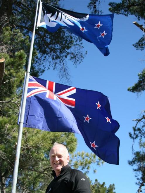 Doug MacKenzie with his preferred flag option and the present New Zealand flag outside his...