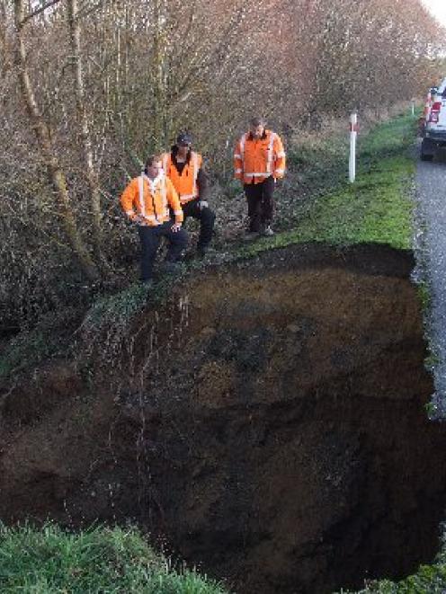 Downer contractors examine the washed-out culvert on State Highway 1 south of Waipahi yesterday...