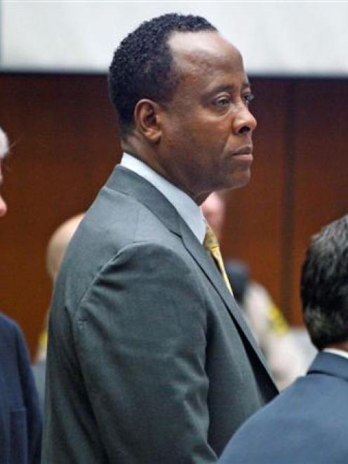 Dr Conrad Murray stands with his attorneys J. Micahel Flanagan and Edward Chernoff during his...