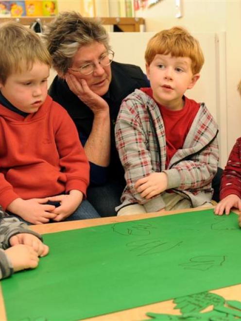 Drawing hand prints as a message of support for the Ako Early Learning Centre are (from left) Nav...