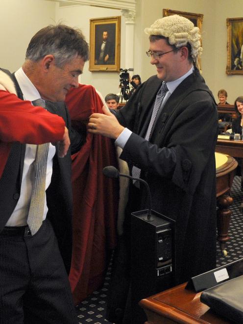 Dunedin City Council chief executive Paul Orders helps Mayor Dave Cull into his robes. Photo by...