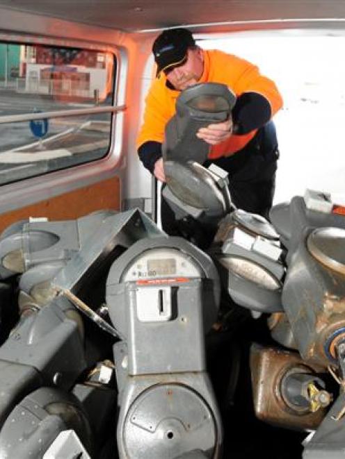 Dunedin City Council parking meter technician Keith Randall collects the last of the city's...