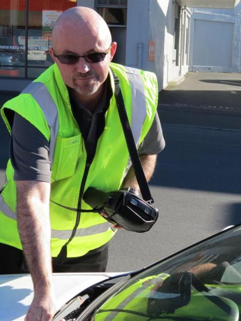 Dunedin City Council parking officer Bevan Mears issues an infringement notice. Photo by Jonathan...