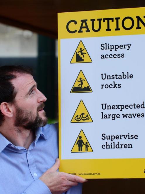 Dunedin City Council project and asset-management team leader Hamish Black with  signs which are...