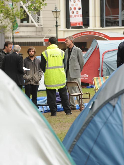 Dunedin City Council representatives, with a security guard, issue a trespass notice to Occupy...