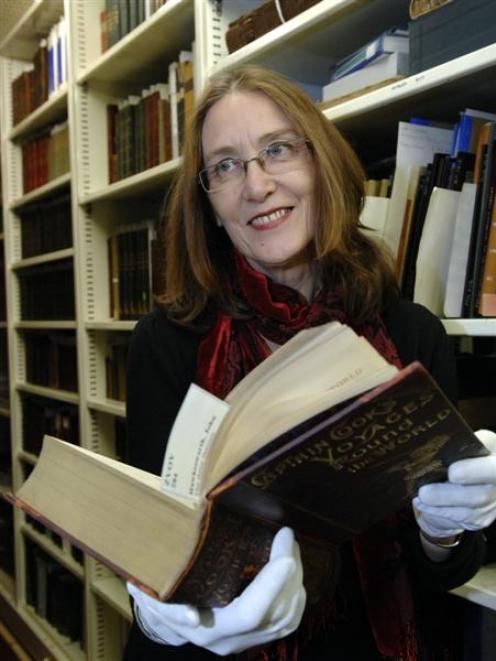 Dunedin City Library head of collection services Linda Geddes holds Captain Cook's Voyages Round...