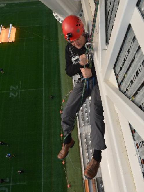 Dunedin Mayor Dave Cull begins his descent for charity from the Forsyth Barr Stadium roof to the...