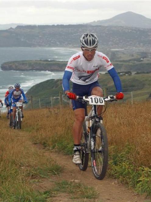 Dunedin mountain biker Jon Richardson (top) climbs Karetai track above Smails beach on the Otago...