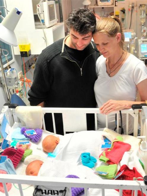 Dunedin parents Alan Bagley and Rebecca Weir look at their 9-day-old twin boys and some knitted...