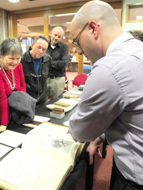Dunedin Public Library rare books librarian Anthony Tedeschi (right) shows one of the thousands...