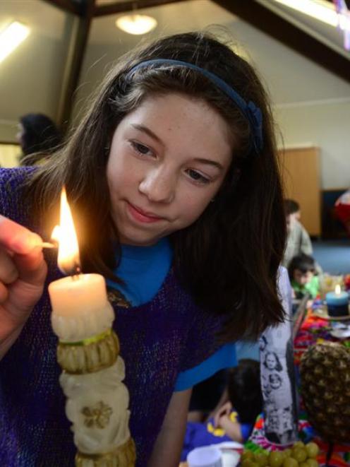 Dunedin pupil Sofia Barriga (12) lights a candle to celebrate the dead in Dunedin on Saturday....