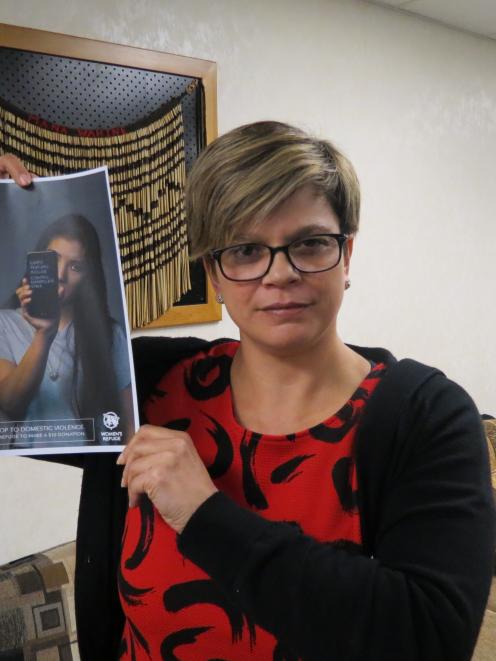 Dunedin Women's Refuge community outreach worker Mandy Durham displays one of the posters used by...