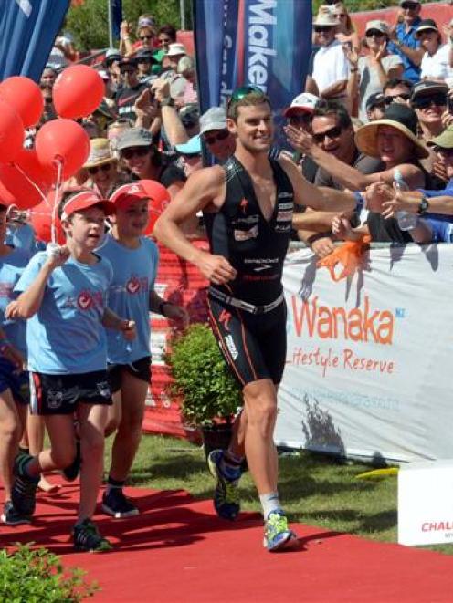 Dylan NcNeice celebrates with the crowd as he runs down the winners shute. Photo by Stephen...