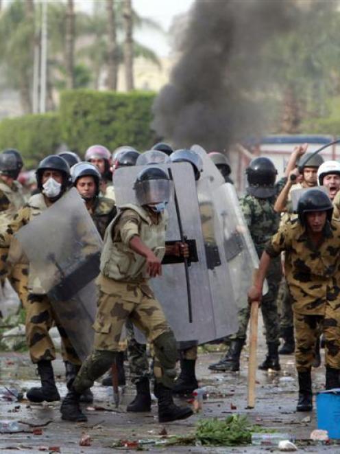 ecurity forces throw stones back at protesters near Egypt's Defence Ministry earlier this month....