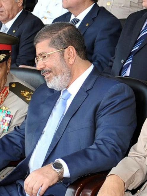 Egyptian President Mohamed Mursi (C) speaks with Field Marshal Hussein Tantawi (L) and Egyptian...