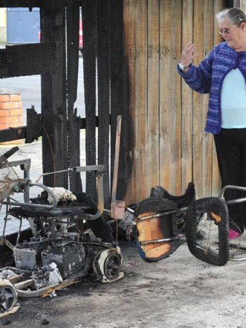 Eleanor Moore inspects the charred remains of her mobility scooter in Mosgiel on Saturday. Photo...