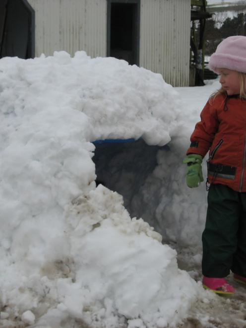 Ella Mooney (3) exits her igloo as the snow starts to melt at her family's Millers Flat property...