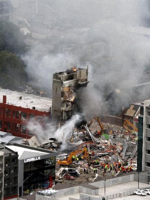 Emergency workers search for survivors in the rubble at the CTV building in Madras St,...