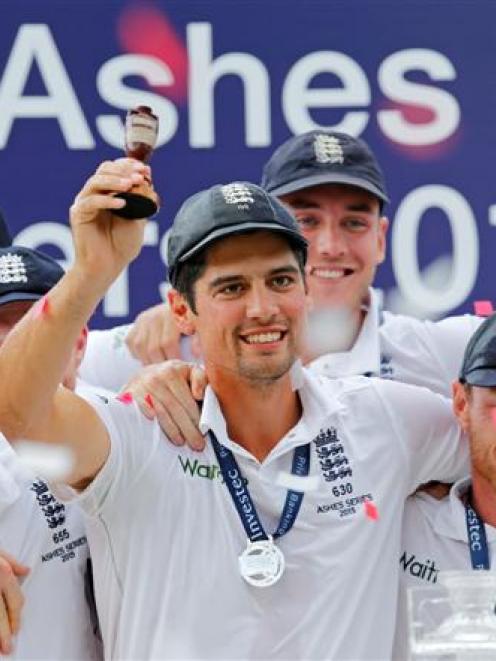 England captain Alastair Cook holds up the Ashes urn as he and his teammates celebrate their...