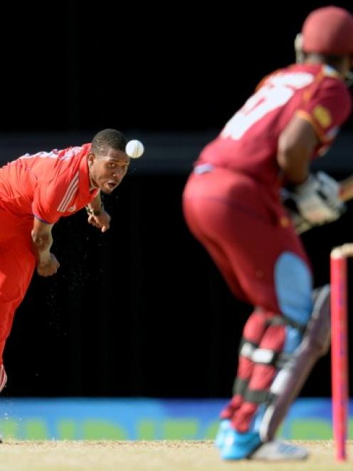 England's Chris Jordan (L) bowls to West Indies' Dwayne Bravo. REUTERS/Philip Brown