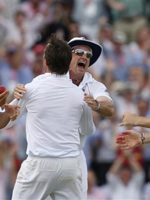 England's Graeme Swann, centre, reacts with Andrew Strauss after Australia's Simon Katich was...
