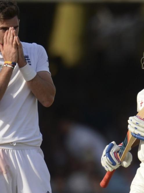 England's James Anderson reacts as India's Ajinkya Rahane (right) collects more runs during the...