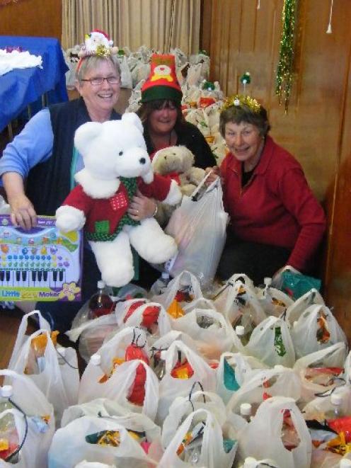Enjoying preparing food parcels and gifts to distribute to  families in need are (from left)...