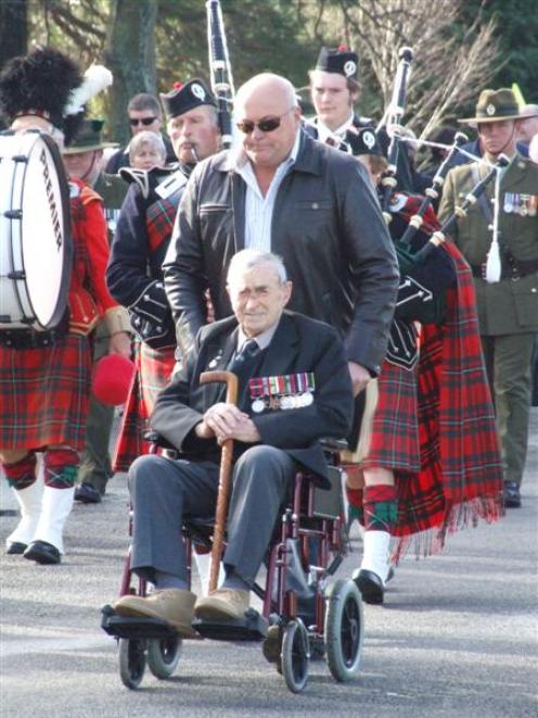 Eric Batchelor, pushed by his son Craig, leads a parade to the Eric Batchelor Pl subdivision...