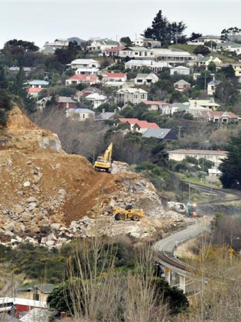 Excavators remove a rock bluff beside the railway line at Sawyers Bay on Tuesday. Photo by Gerard...