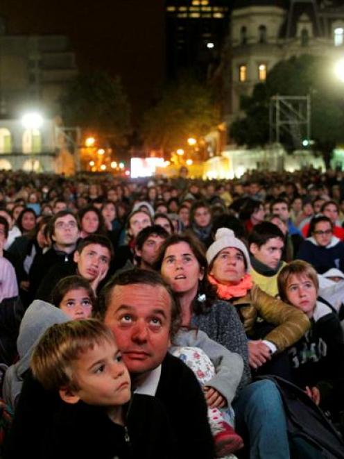 Faithful gather before dawn to watch a televised broadcast of the inaugural mass of Pope Francis...