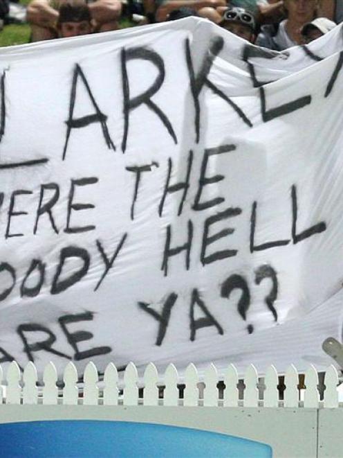 Fans hold up a banner for missing Australian player Michael Clarke who left the tour of New...