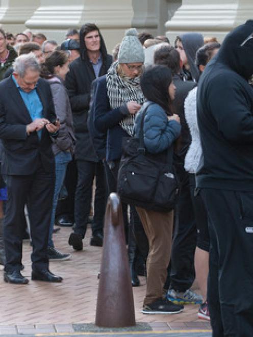 Fans queue to buy tickets for the weekend's Super Rugby final from the Ticketek office in...
