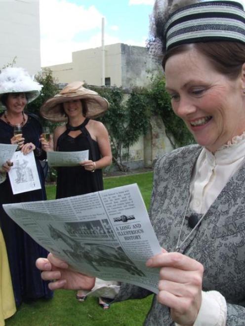 Fashion-in-the-field contender Tania Pacey reads a souvenir copy of the racing edition of The...