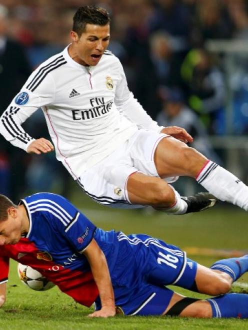 FC Basel's Fabian Schaer (L) fights for the ball with Real Madrid's Cristiano Ronaldo during...