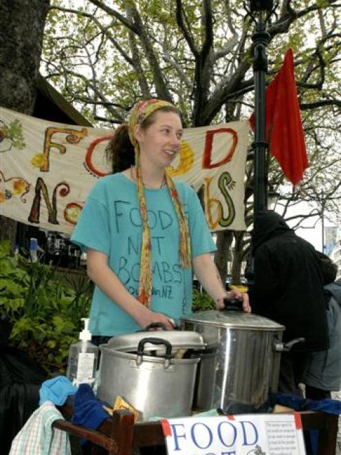 Feather Shaw (19), of Dunedin, braves steady drizzle to run the "food not bombs" stall at...
