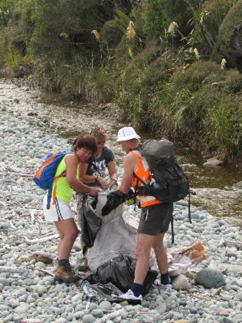 Filling a fadge with rubbish between Barn Bay and Sandrock Bluff are (from left) Marietta Gibb,...