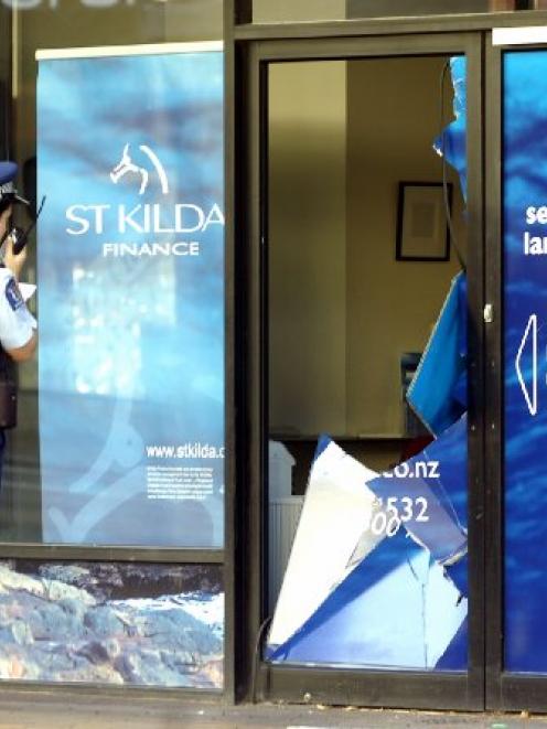 Night time damage.... Constable Louise Pearce surveys the damage to St Kilda Finance office in...