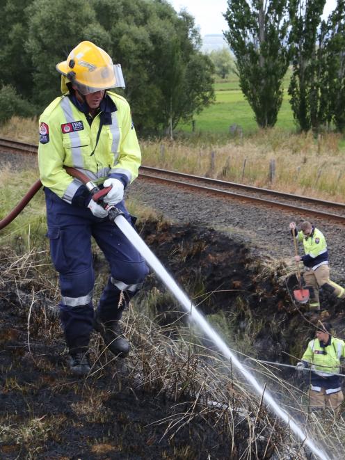 Firefighters at the scene of a grass fire along State Highway 1 near Henley yesterday.  Photo by...